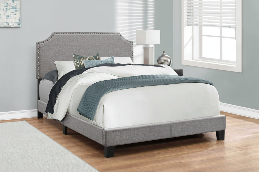Grey linen full bed frame with nailhead trim, stylish and sturdy, by Meuble Divino, showcasing its elegant design and headboard details.