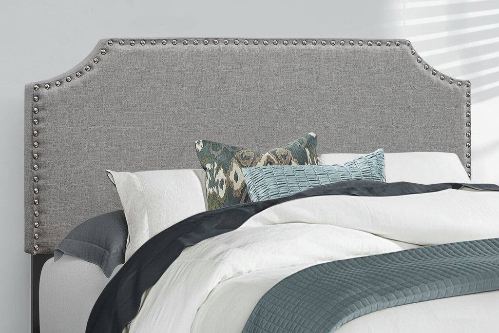 Grey linen full bed frame with nailhead trim and wooden legs, featuring a modern, upholstered design for a stylish bedroom.