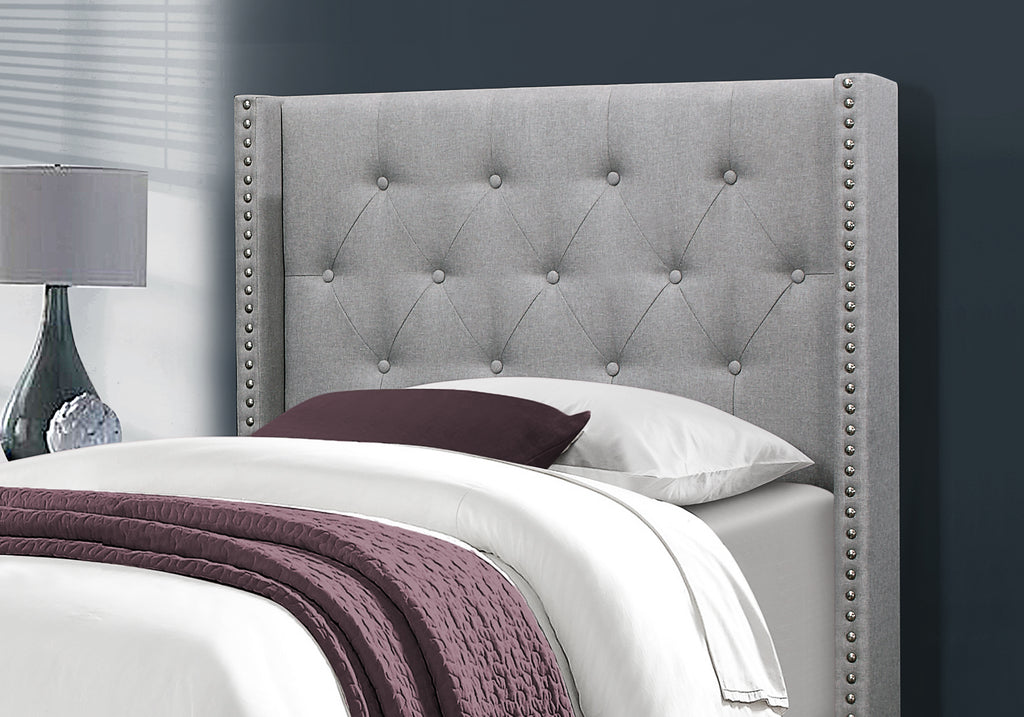 Grey upholstered platform bed with tufted headboard and nailhead trim, featuring a sleek, modern design by Meuble Divino.