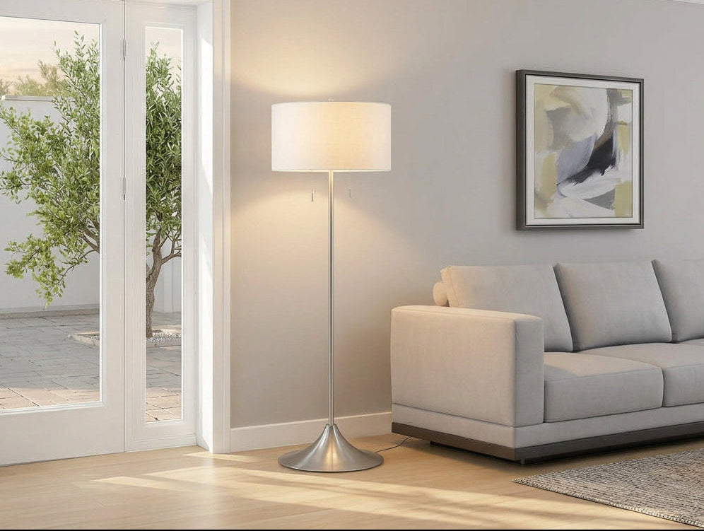 Meuble Divino Harper drum shade floor lamp with beige fabric drum shade and sleek metal base, standing on a wooden floor.
